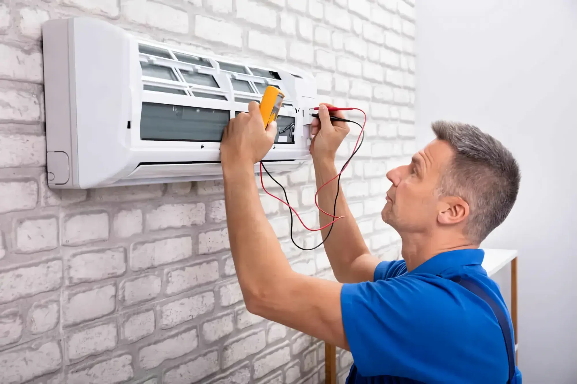 AC technician testing a split air conditioner with a multimeter, AC repair and maintenance services in Dubai by Limech
