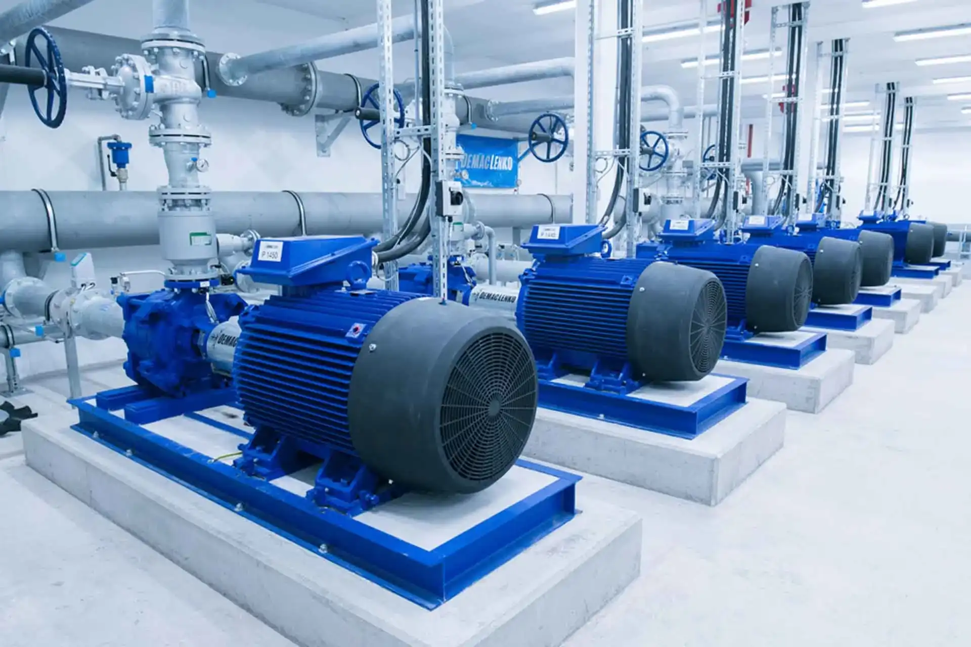 Row of industrial water pumps and pipework in a pump room, pump maintenance and plumbing services for commercial buildings in Dubai by Limech